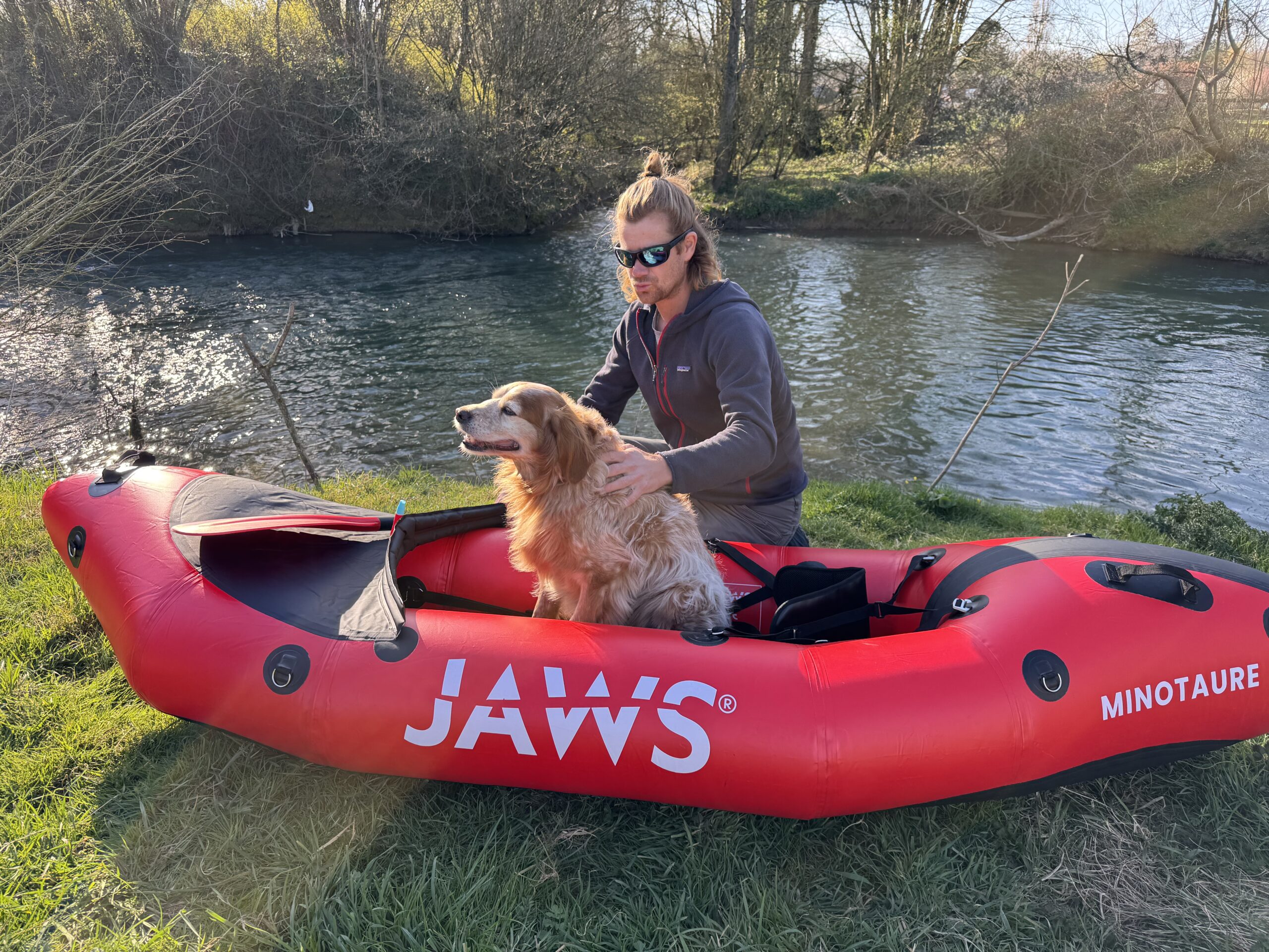Antoine Bruge et son chien dans un packraft au bord de l'eau