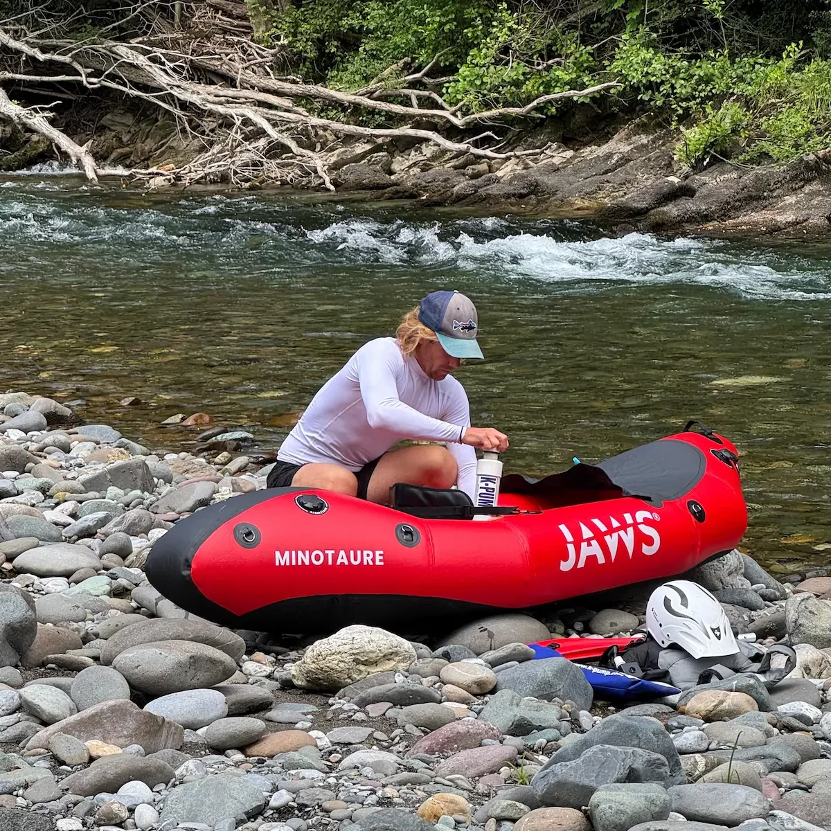 Antoine Bruge, moniteur de kayak, gonfle un packraft Jaws Minotaure sur les berges du gave d’Aspe